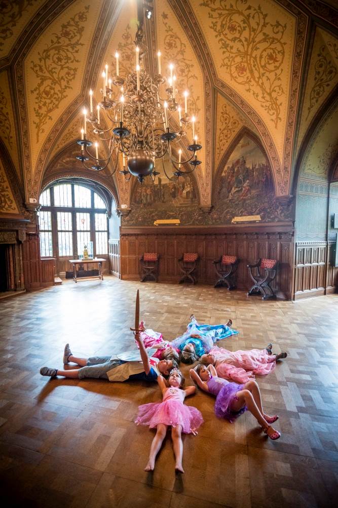Kinderen in een cirkel onder een luster van het kasteel