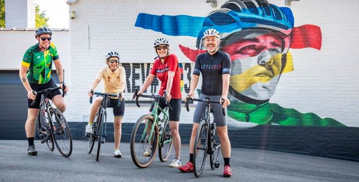 Wielrenners aan muurschildering van Remco Evenepoel