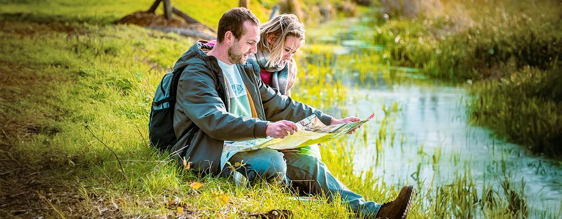 2 wandelaars rusten uit langs beekje